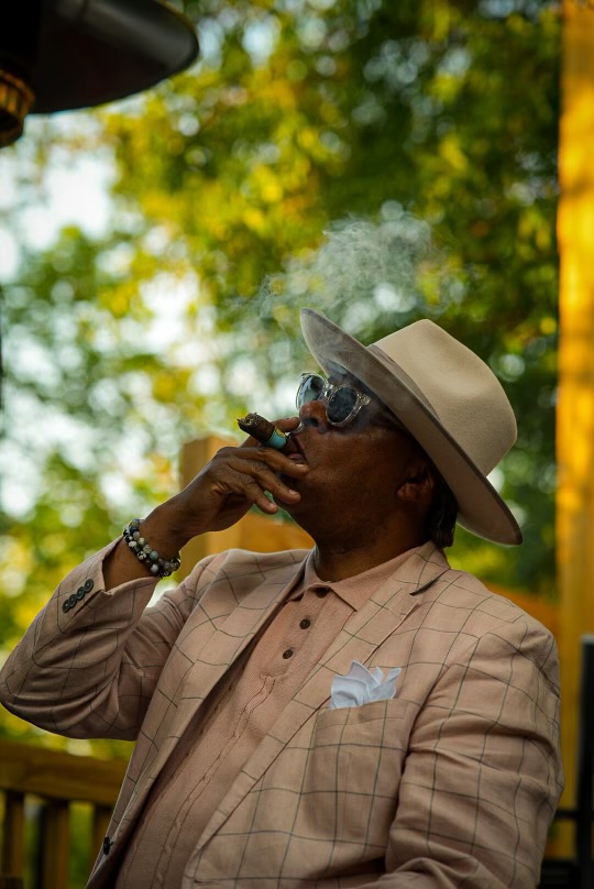 A guest in a linen suit enjoying a cigar outdoors