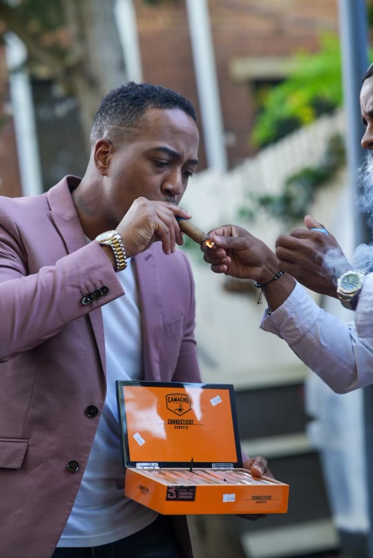 Two guests lighting a Camacho Connecticut cigar together