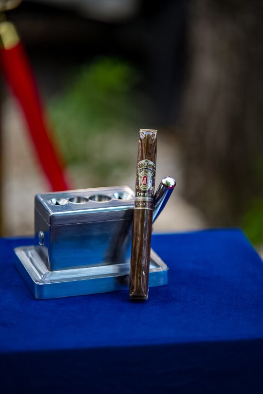 A premium cigar and torch lighter on the lounge's outdoor side table