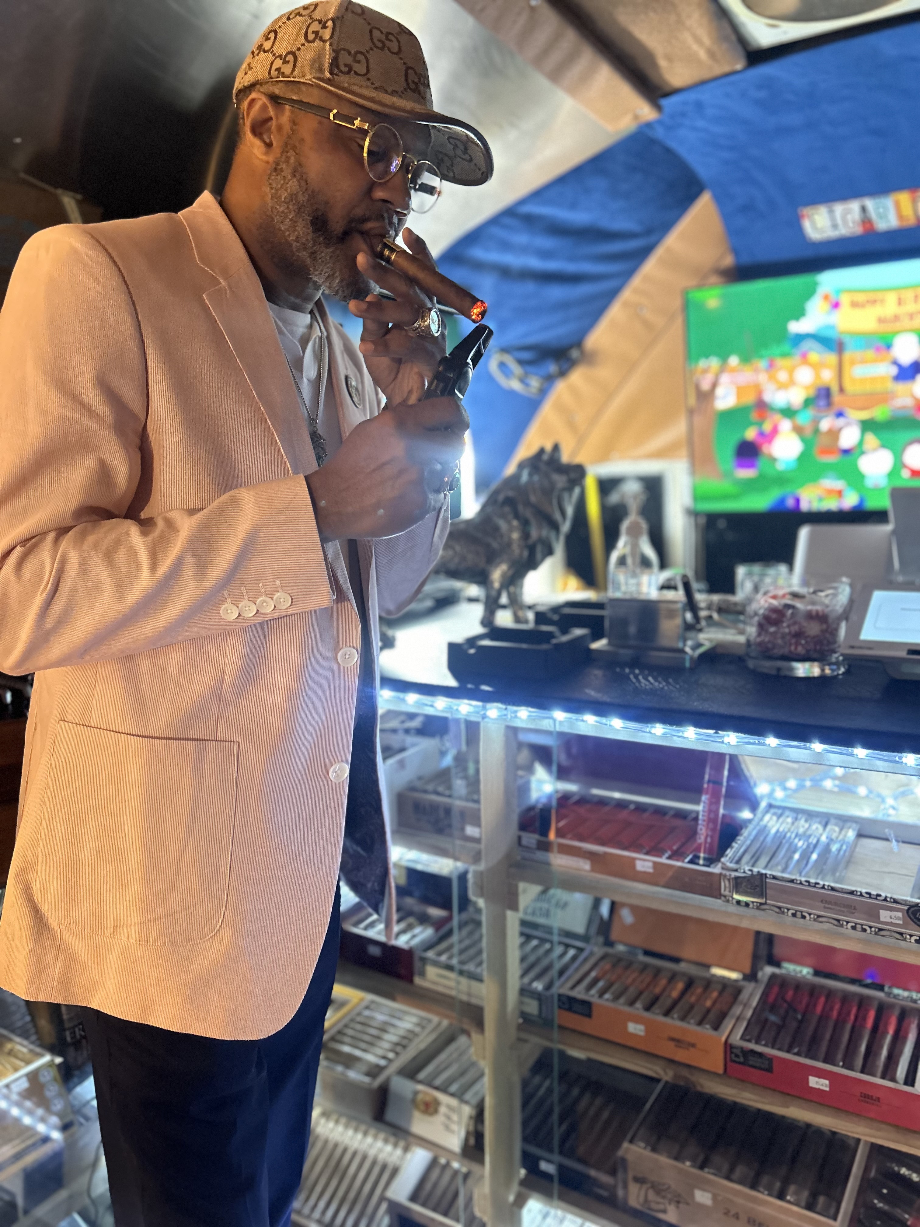 A guest enjoying a cigar beside the fully stocked Airstream humidor case