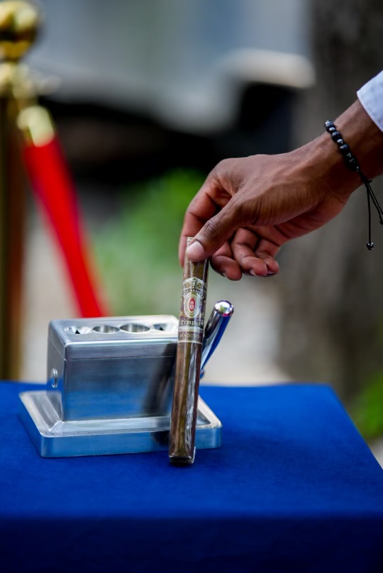A cigar held beside the lounge's silver cigar stand